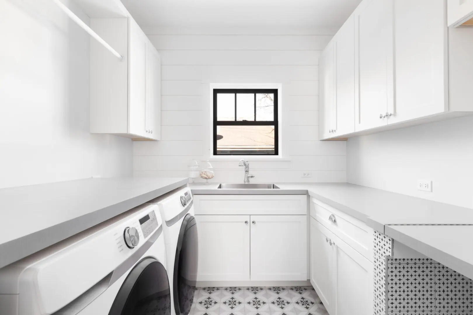 A white kitchen with a window and sink.